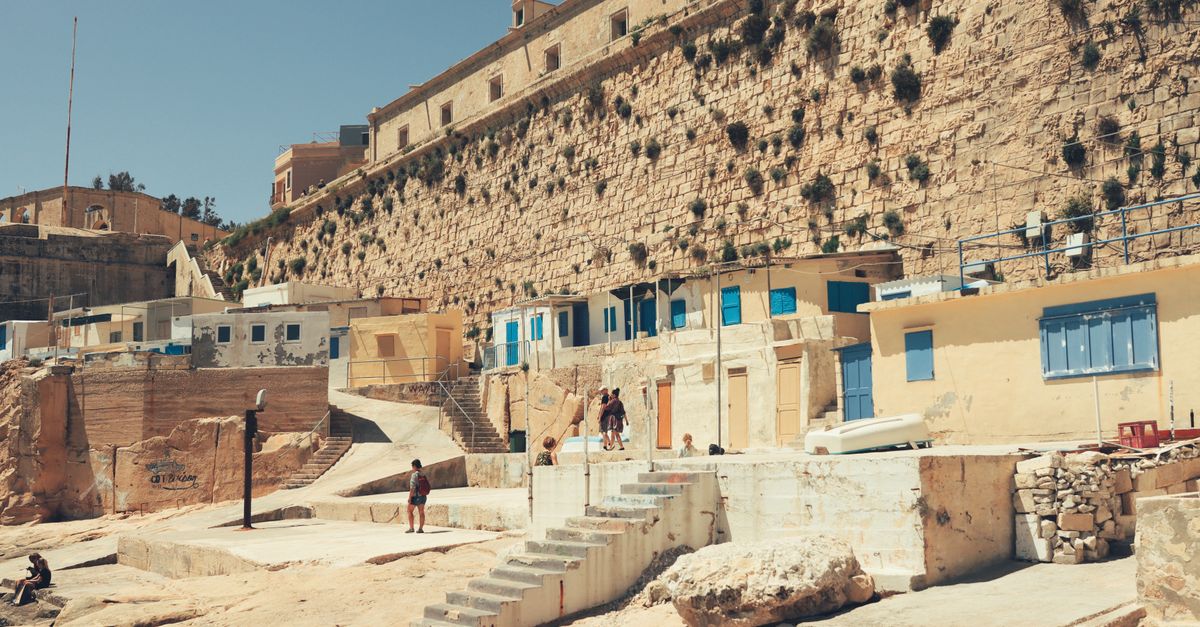 Sunlit stone walls of Valletta Malta in summer heat illustrating why indoor air conditioned gyms matter