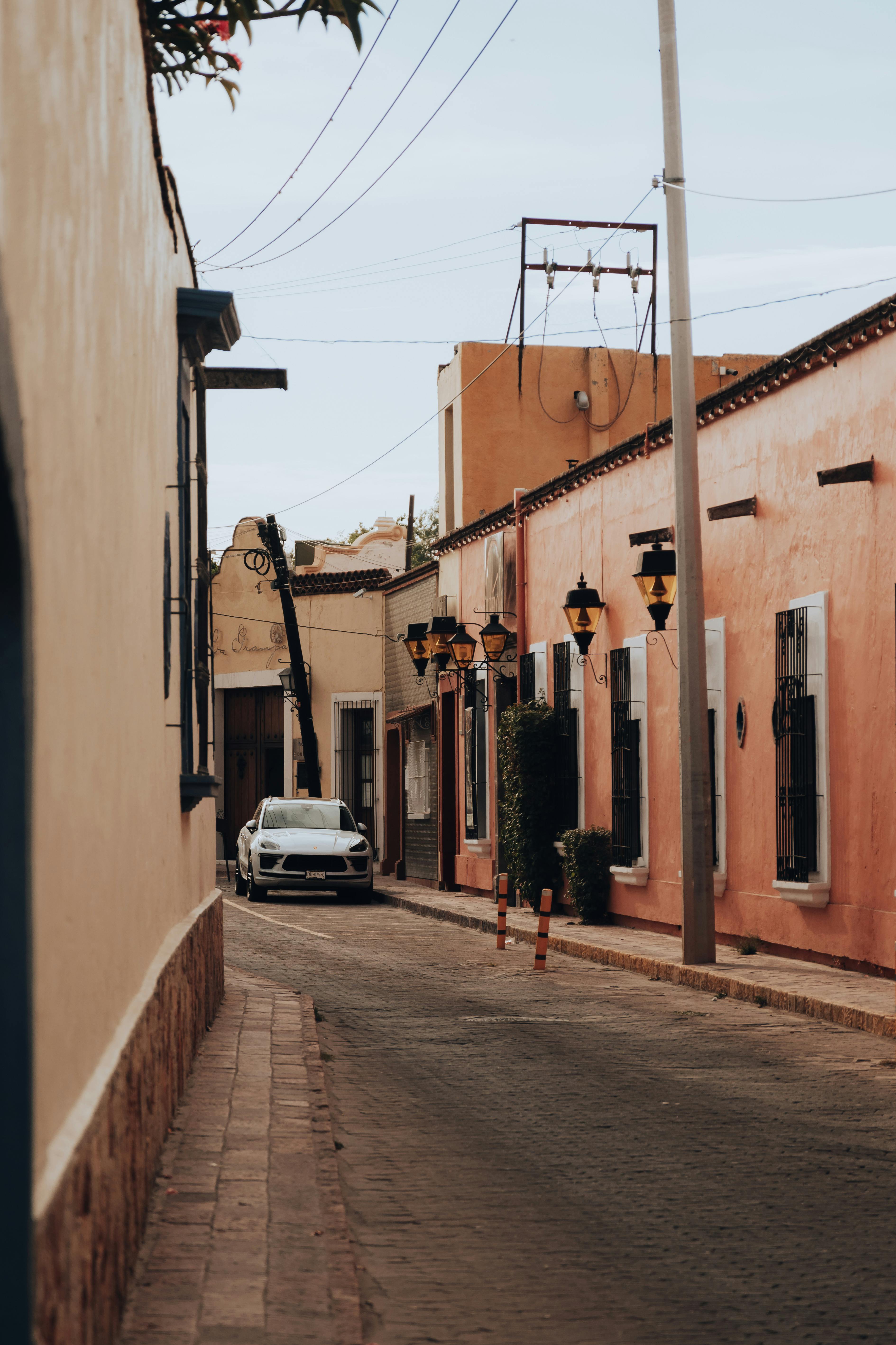 Colorful street in Tequisquiapan, Mexico with traditional architecture and a parked car.