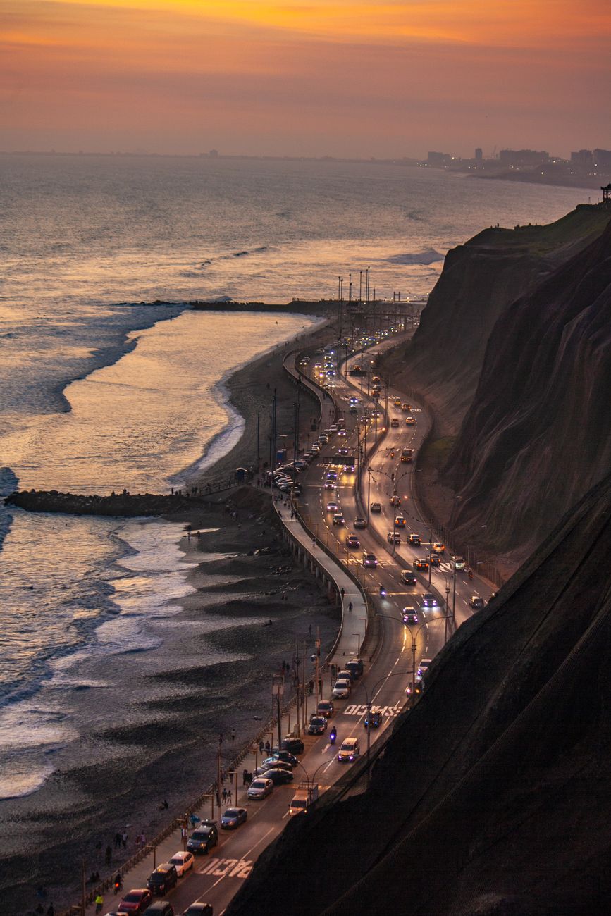 Winding coastal cliff road overlooking the ocean at golden hour