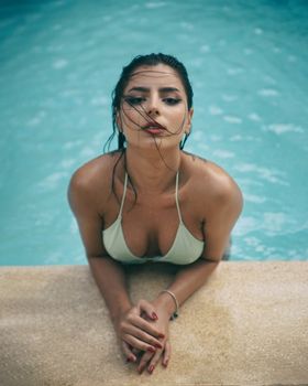 Stylish woman in swimwear posing confidently by a pool in Bayahíbe, Dominican Republic.