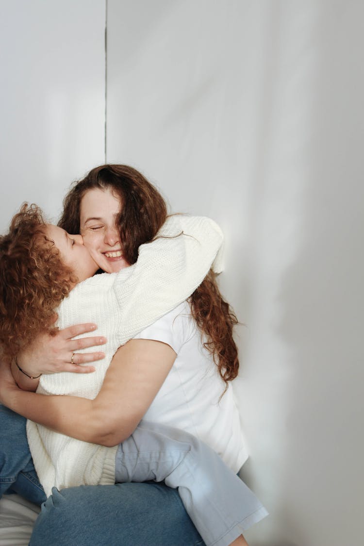 Child Hugging And Kissing Mother