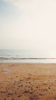 Tranquil sandy beach with calm sea and clear skies in AN, India.