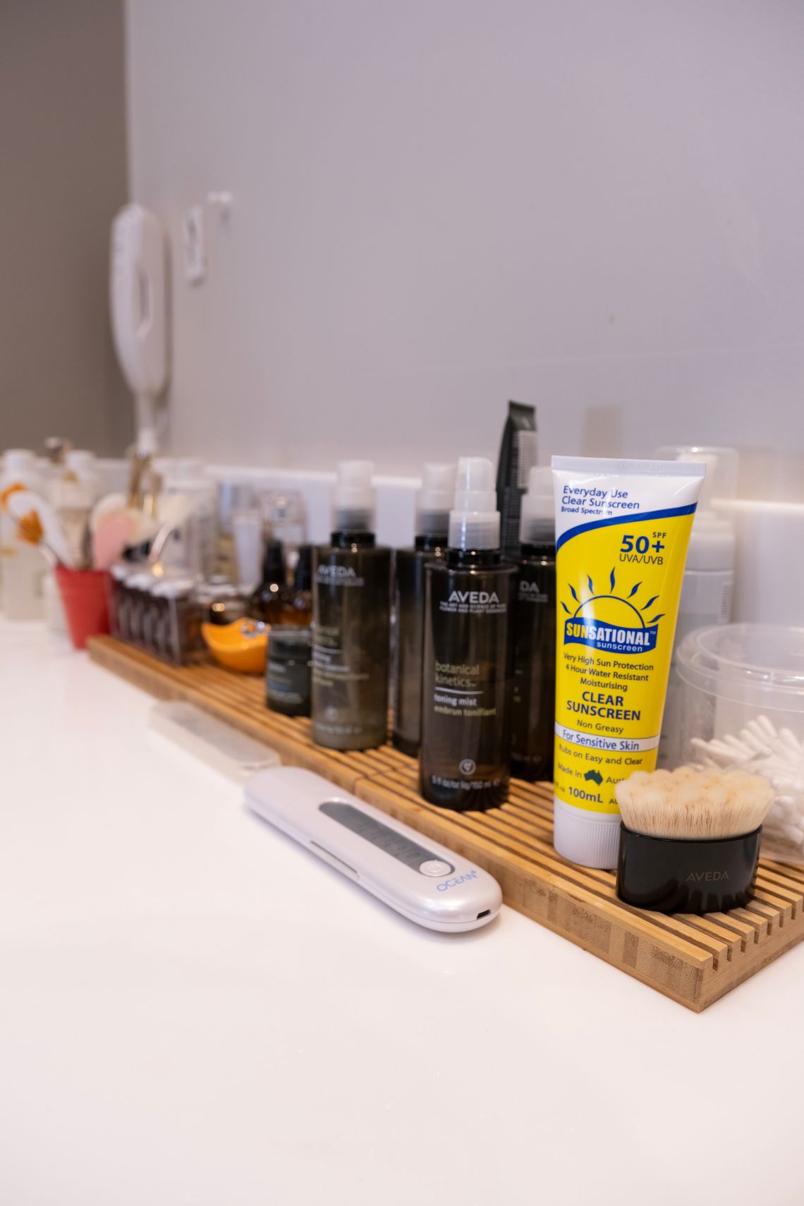 Skincare, sunscreen, grooming, and oral-care products arranged on a bathroom shelf