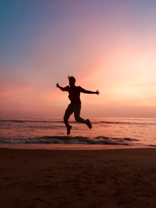 Silhouette of Jumping Man during Sunset