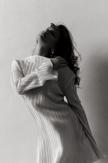 Stunning black and white portrait of a woman in a long dress, exuding elegance and style.