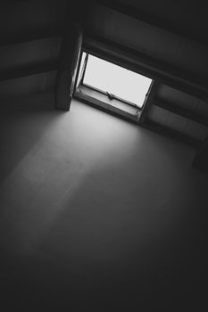 A dramatic black and white photograph of a skylight in a loft, casting light into the room.. pexels, dramatic, black