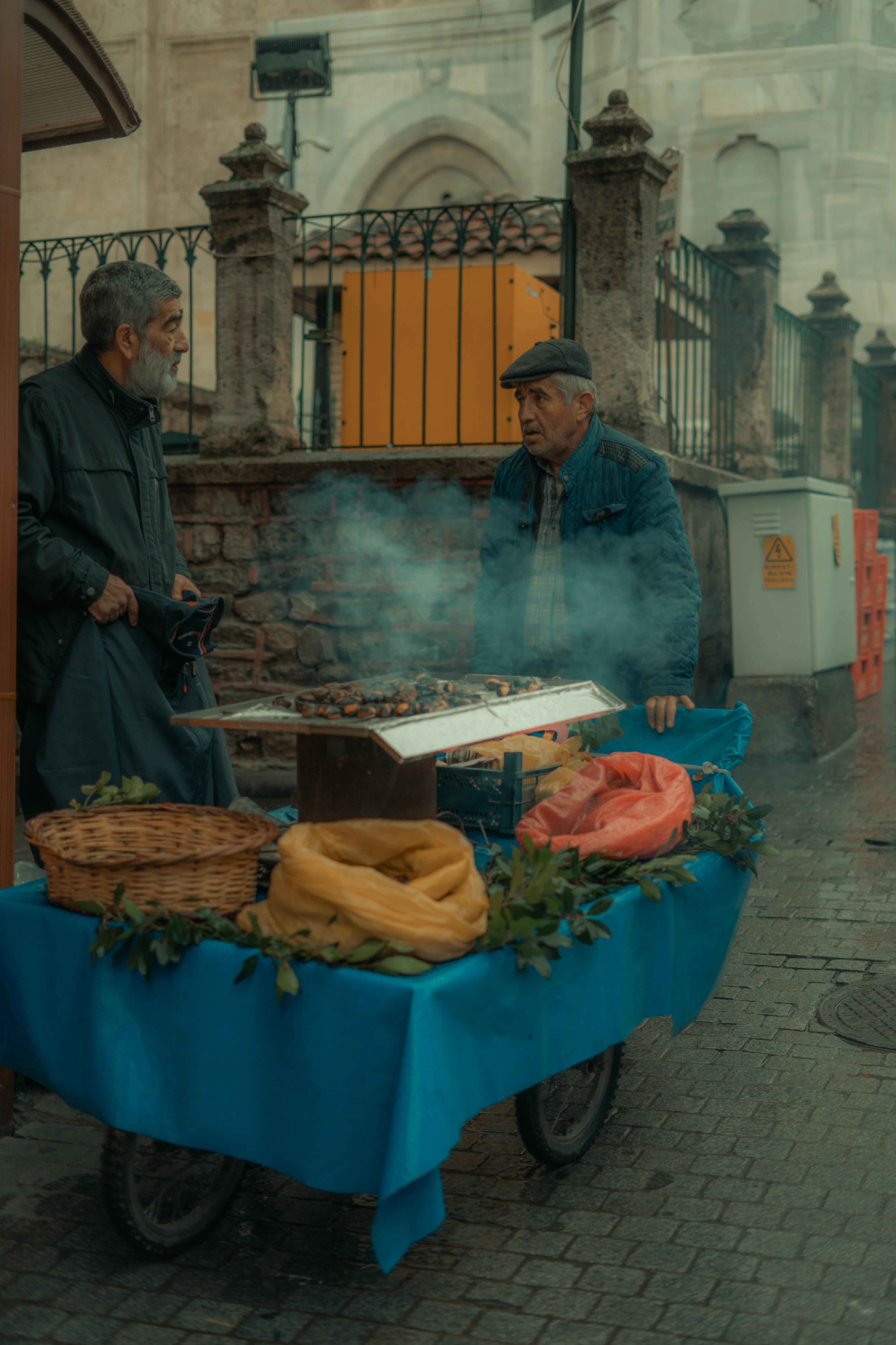 Free Elderly men selling roasted chestnuts at a food stand in Bursa, Turkey. Stock Photo