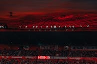 赫罗纳足球俱乐部比赛期间，体育场座无虚席，上方是戏剧性的红色日落天空