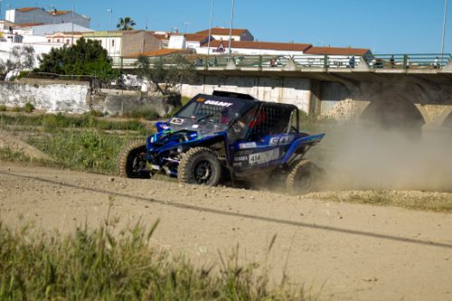 Free Quad bike racing on a dusty dirt track in Alconchel, Spain, showcasing thrilling off-road action. Stock Photo