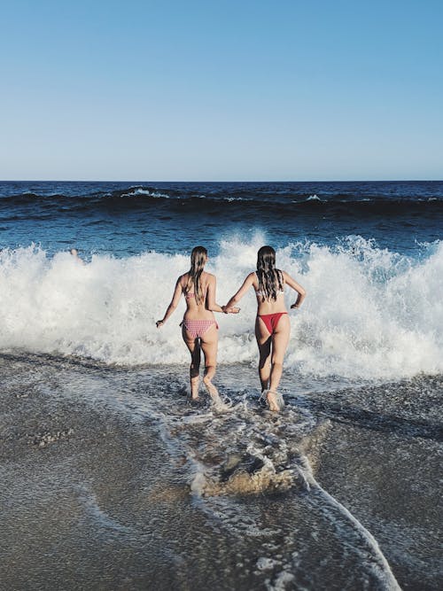 Women in Bikinis Running Towards Shore