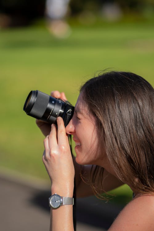 Woman Holding Camera in Bokeh Photography