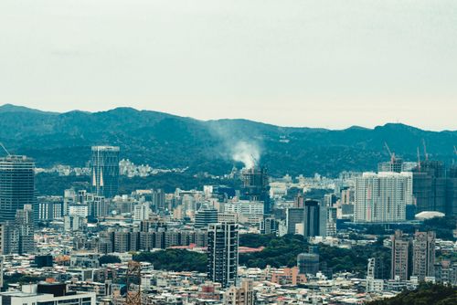 Free Expansive cityscape with skyscrapers and hills in the background. A daytime view. Stock Photo