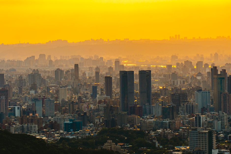 Stunning aerial cityscape with skyscrapers silhouetted against a vibrant yellow sunset sky.