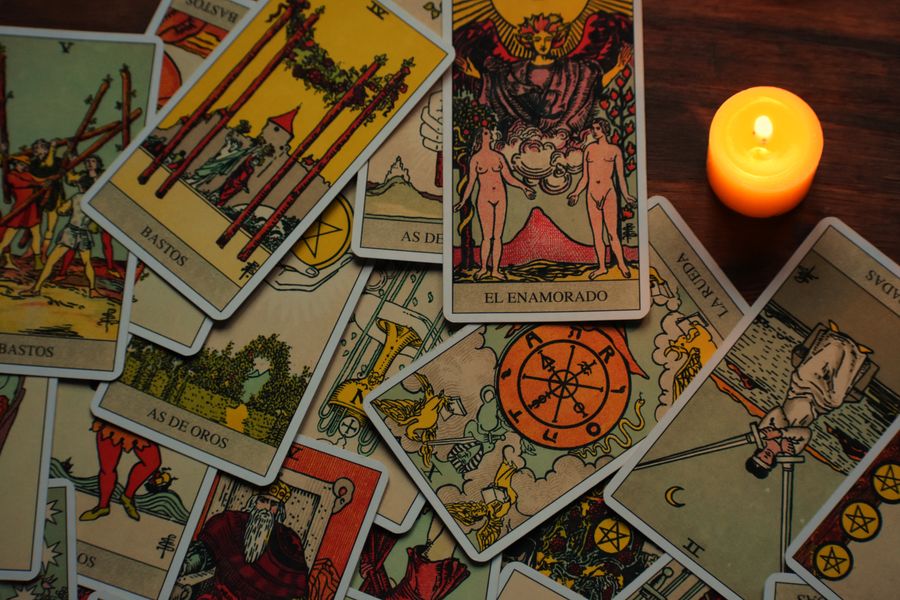 Cards spread on a table beside a lit candle