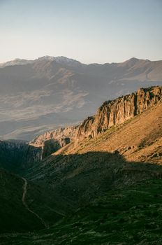 A vast and rugged mountain landscape basked in the warm glow of the sunrise.