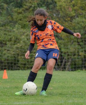Focused young soccer player on the field showcasing skills during a match.