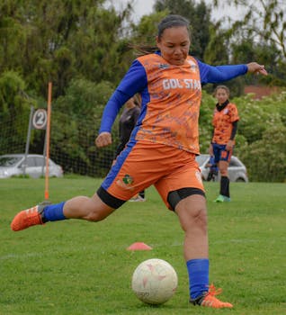 Focused female soccer player in action during a match on a grassy field.