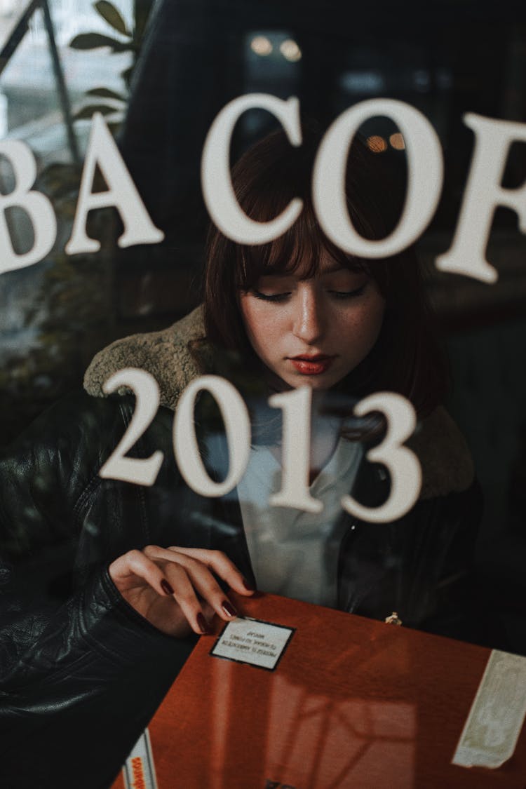 Woman Behind A Restaurant Window Looking At Menu 