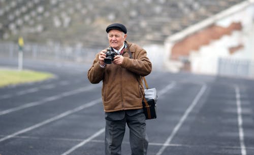 An older man is taking a picture of a track