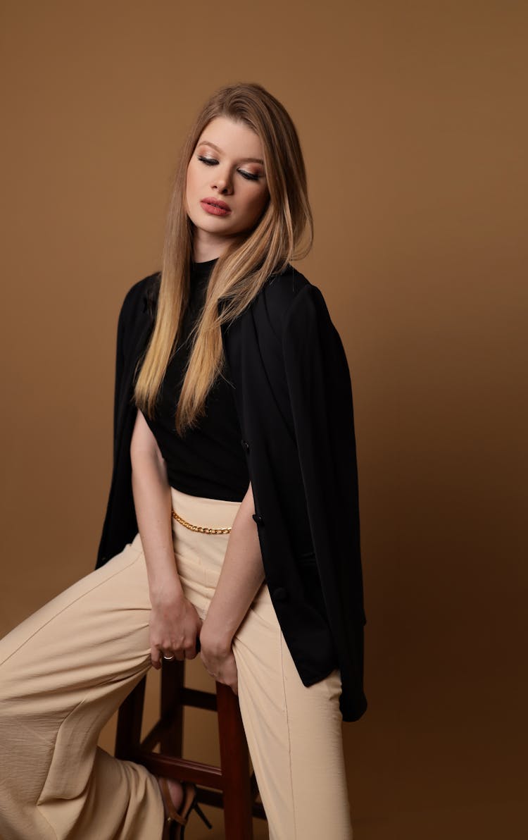 Young Woman Posing On Chair In Studio