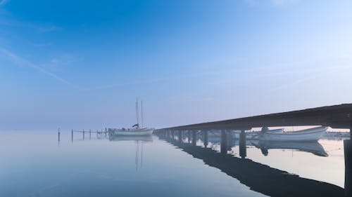 Boats Moored near a Pier under a Clear Blue Sky 