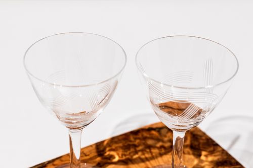 Free Two elegant crystal glasses placed on a textured wooden surface, capturing refined simplicity. Stock Photo