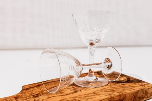 Free Two elegant crystal glasses on a rustic wooden board, perfect for dining or bar display. Stock Photo