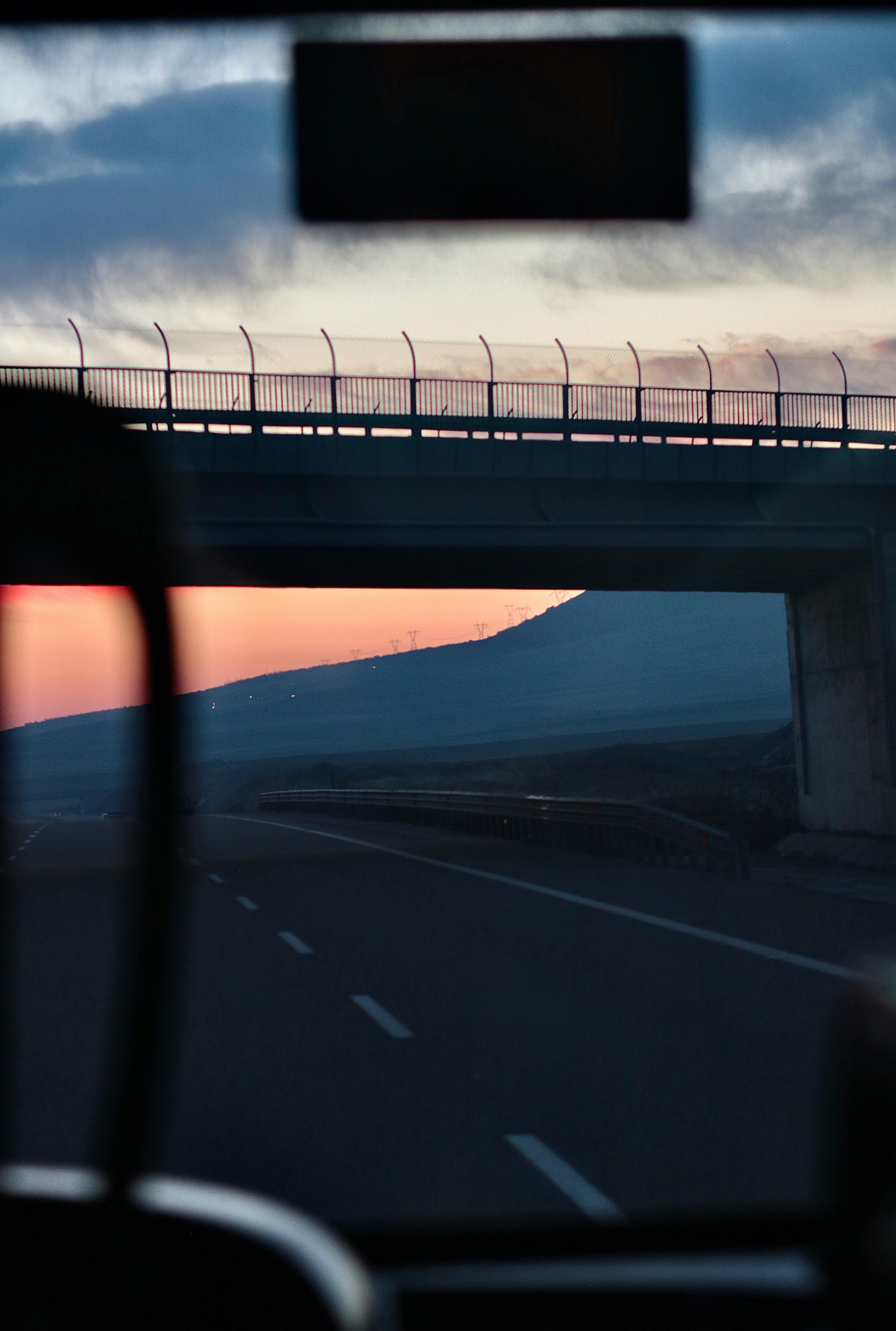 Route de montagne au coucher du soleil vue de l'intérieur d'une voiture