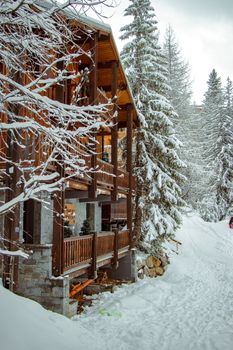 Rustic wooden chalet in a picturesque snowy forest setting, perfect for winter getaways.