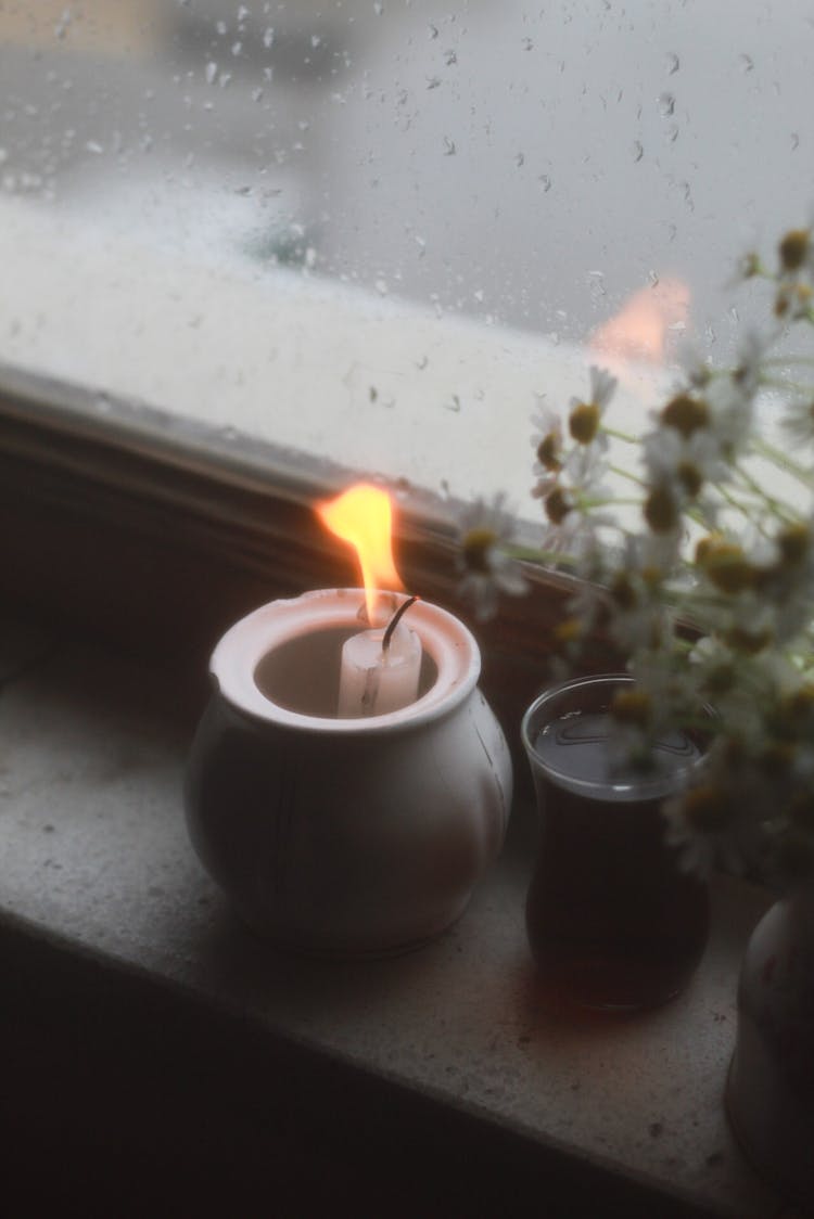 Burning Candle On Windowsill