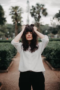 Portrait of a woman with long hair standing in a park in Belo Horizonte, Brazil, with eyes closed.