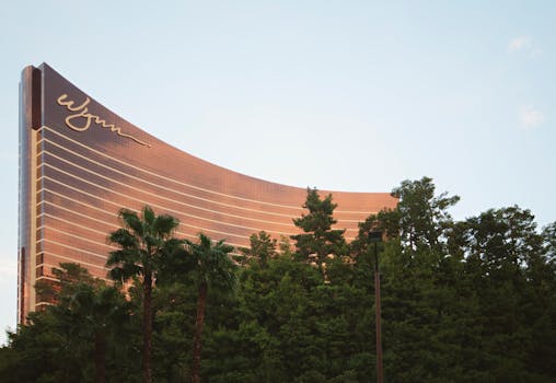 Stunning view of the Wynn Hotel in Las Vegas with greenery and a clear blue sky.