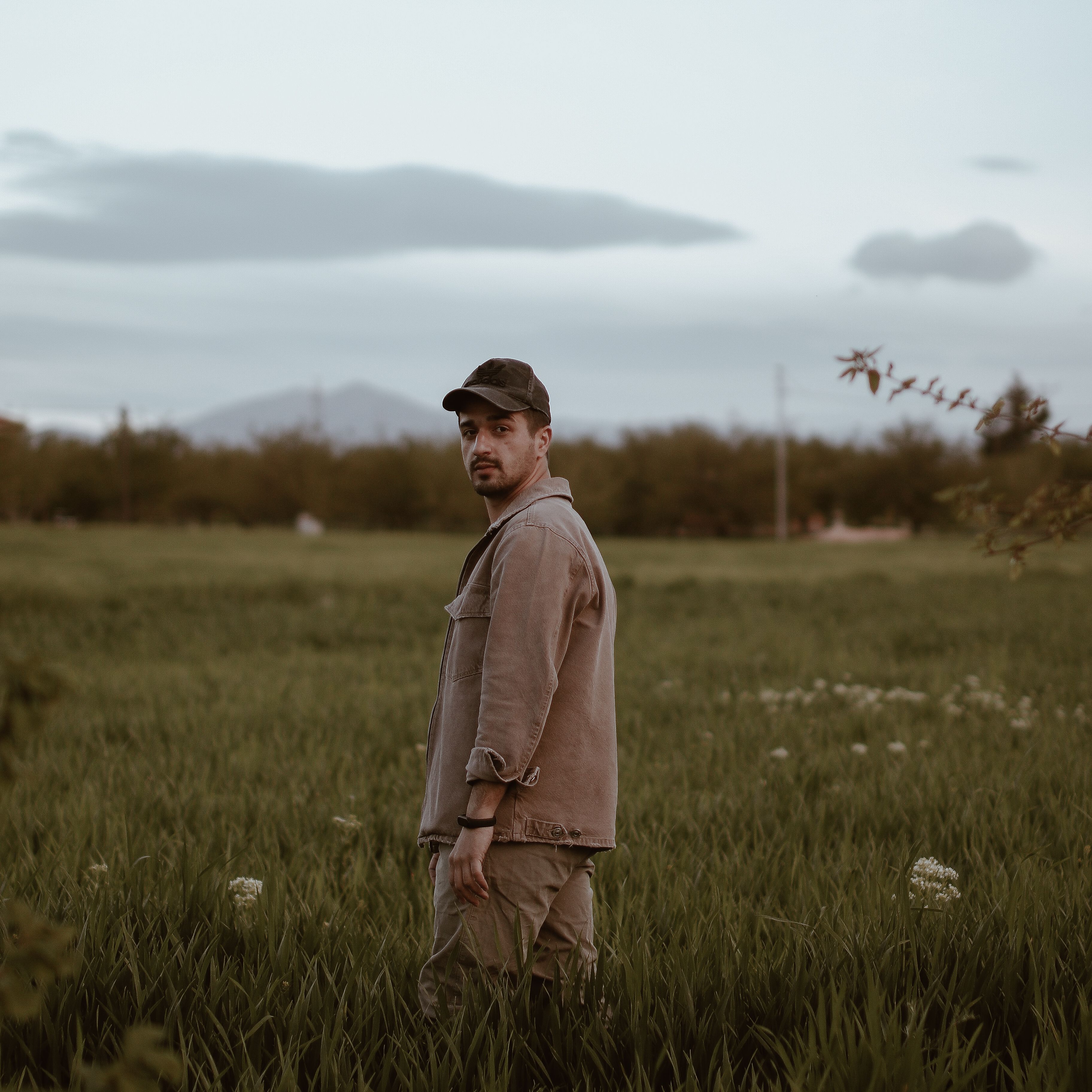 Man standing in a green meadow under open sky — photo by Yakup Polat on Pexels