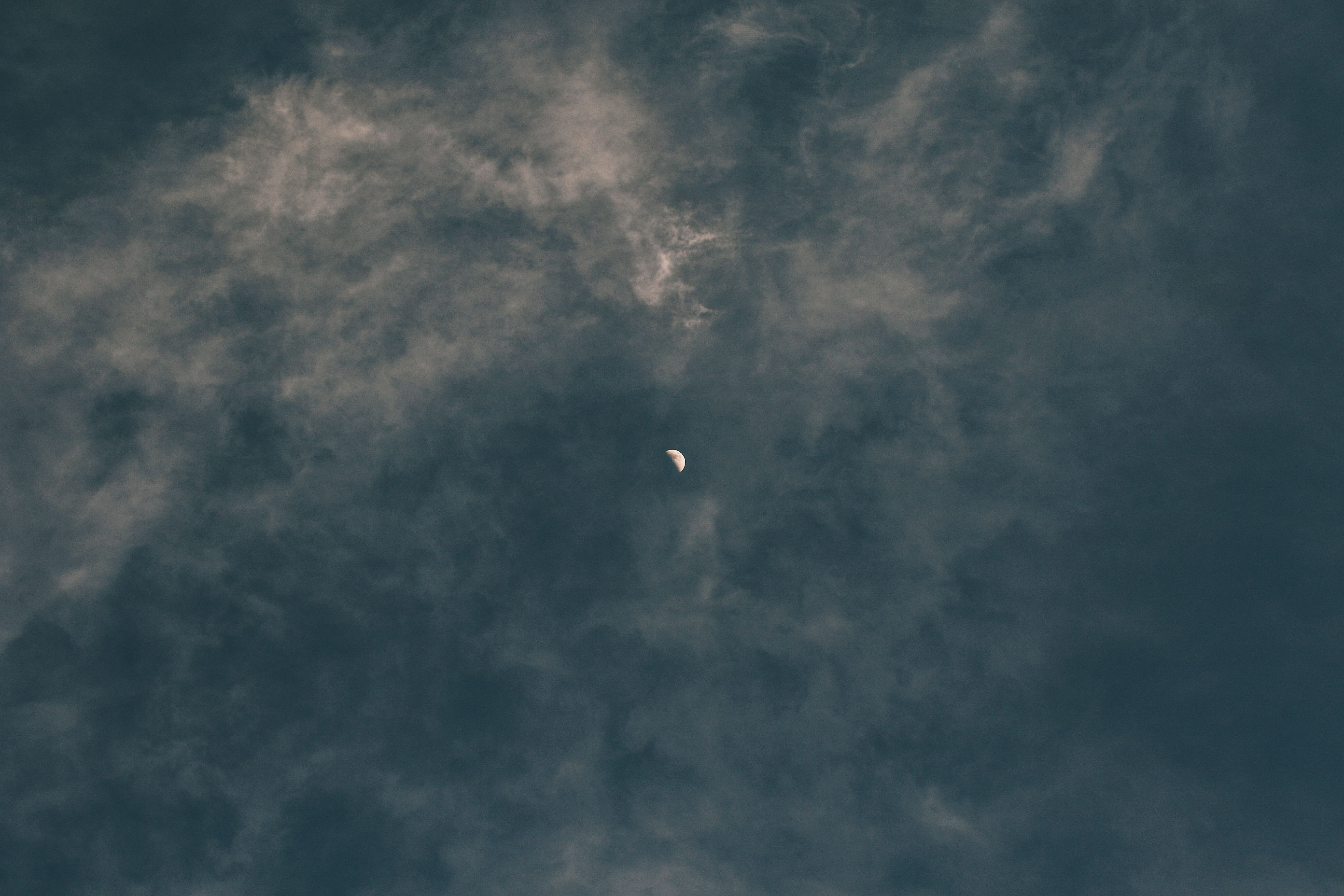 A crescent moon among clouds at twilight