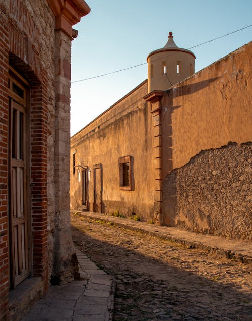 Sunlit Wall near Cobblestone Street in Town