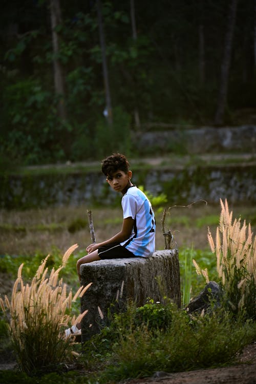 Boy Sitting on Stone Block