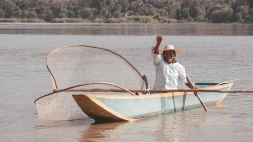 Foto profissional grátis de barco de pesca, camisa, chapéu