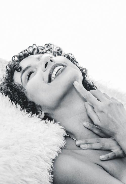 Woman Smiling and Lying Down in Black and White