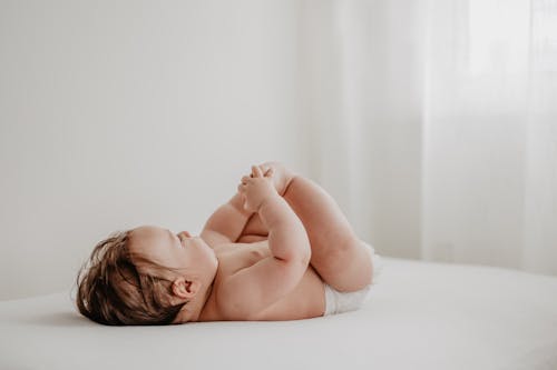 Free Baby Lying on Bed Stock Photo