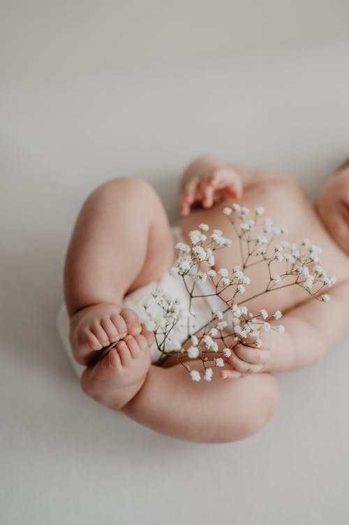 Baby Holding Delicate Flowers