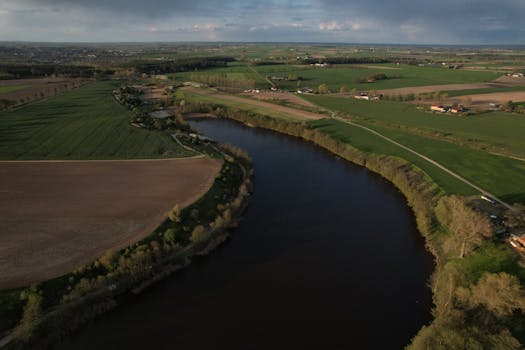 Peaceful countryside landscape with a winding river captured from above.