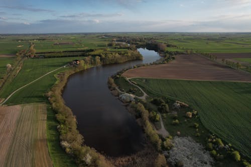 Aerial Photo of a River Flowing Through the Fields