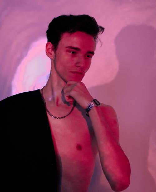 A Young Man with Bare Chest in Pink Light