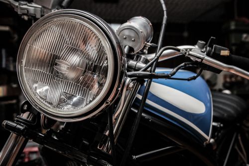 Free Detailed view of a classic motorcycle's headlight and handlebars, showcasing retro design. Stock Photo