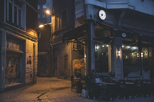 A dimly lit urban alleyway with graffiti and closed shops at night, perfect for urban exploration themes.