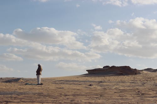 Person in Jacket Standing on Sandy Land