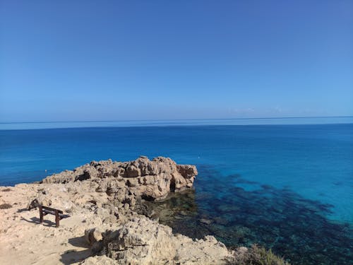 Blue Seascape and a Bench on a Rocky Coast