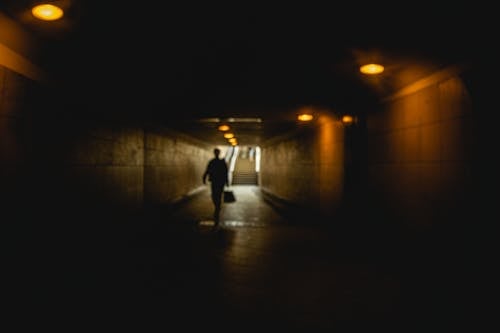 Person with Bag in Dark Tunnel