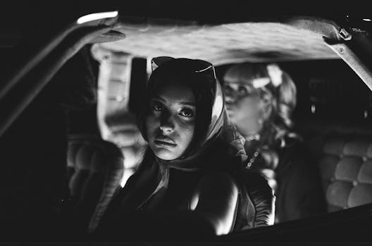 Vintage-style black and white portrait shot inside a car in Los Angeles.