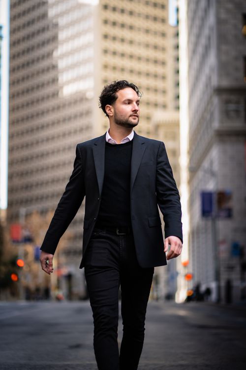 Free A stylish businessman confidently strolling through an urban setting, exuding success. Stock Photo